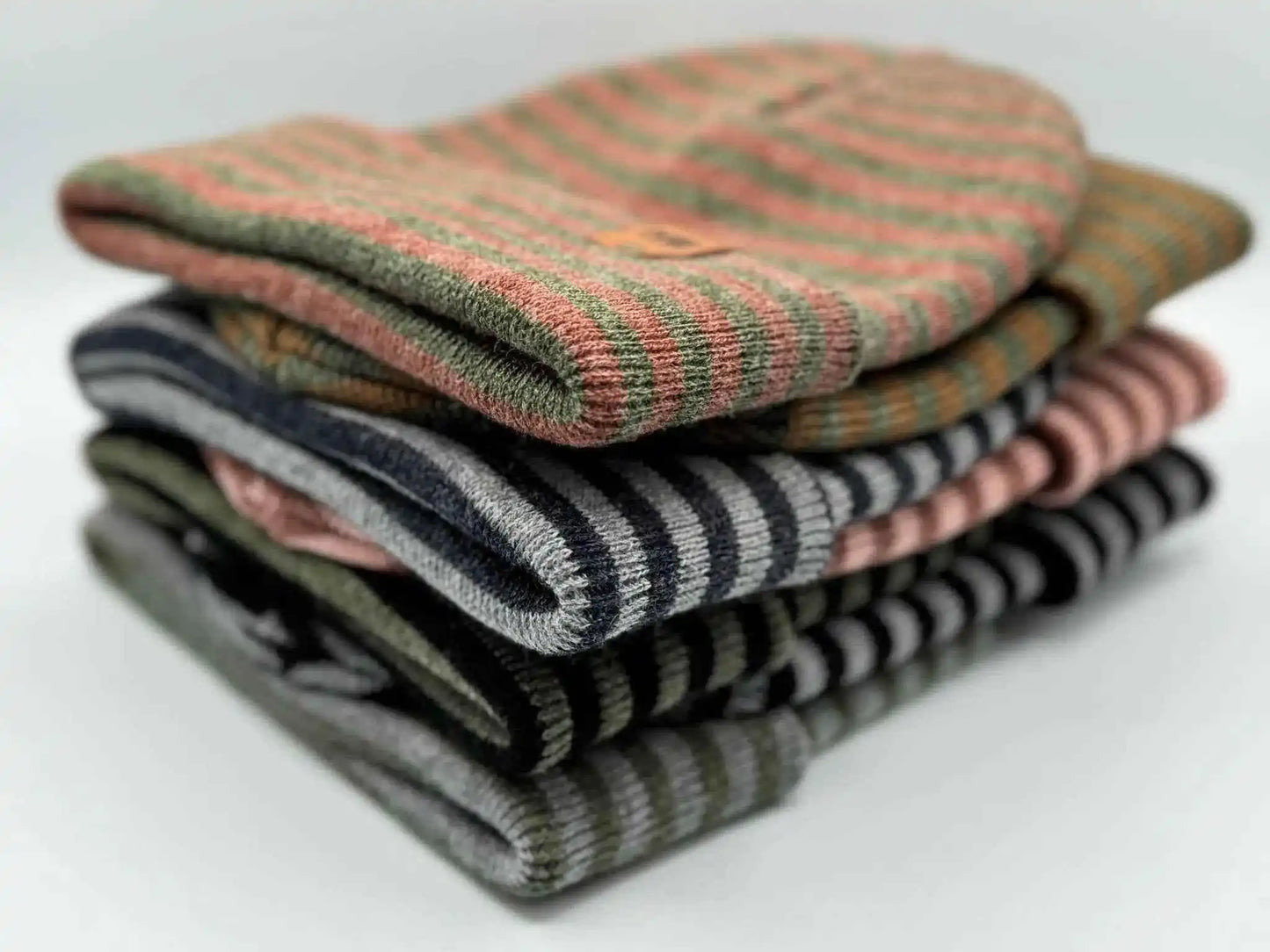 Stack of striped knit beanies with cuffs in mixed colors
