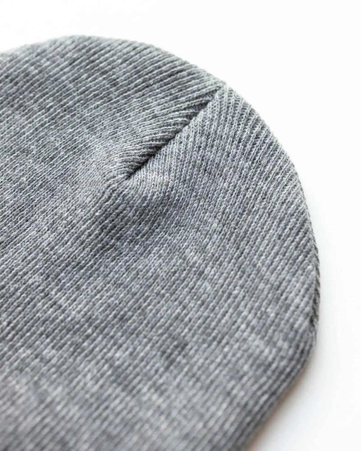Gray knit beanie close-up with textured fabric and top seam