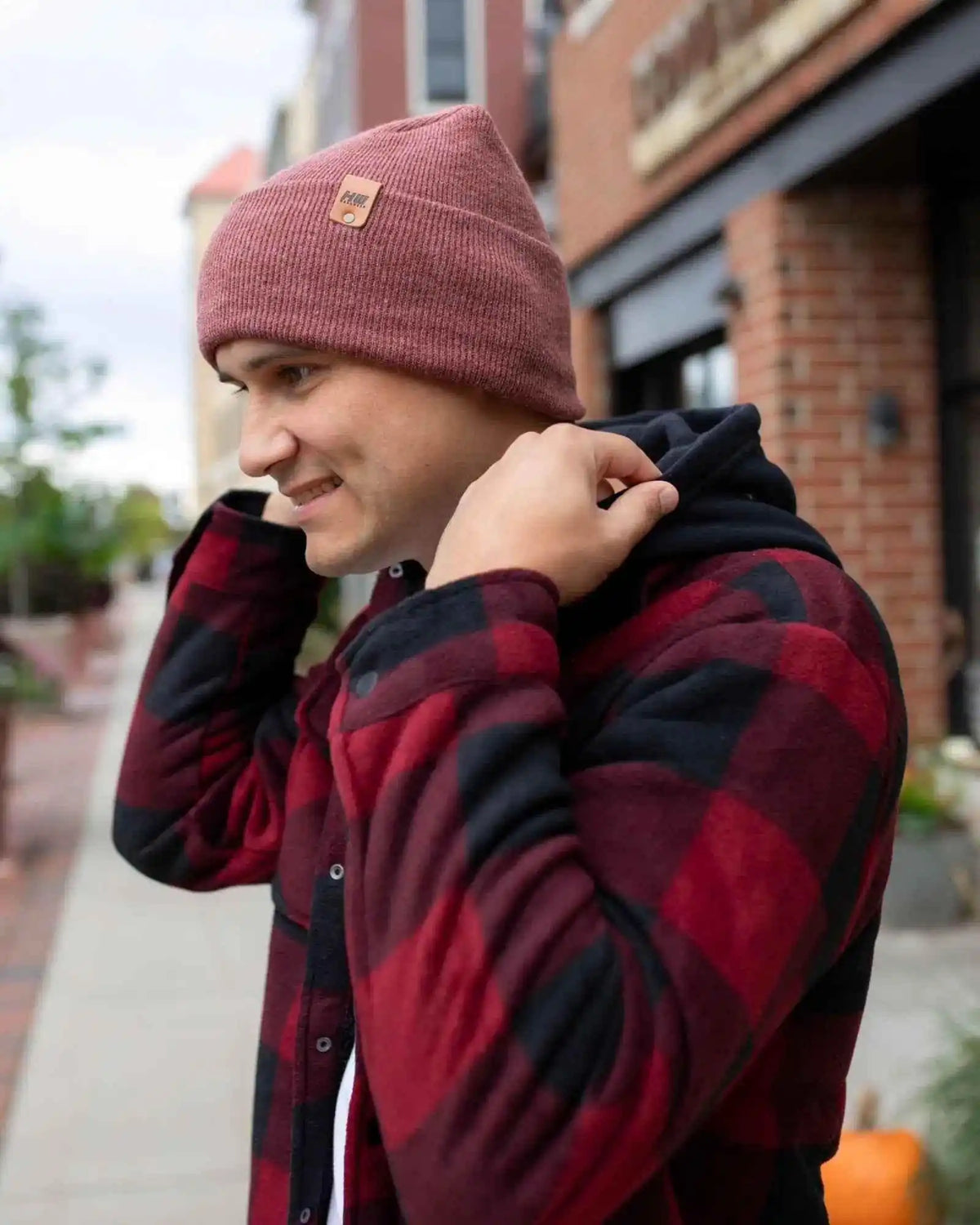 Rusty burgundy cuff knit beanie with small leather patch near the fold