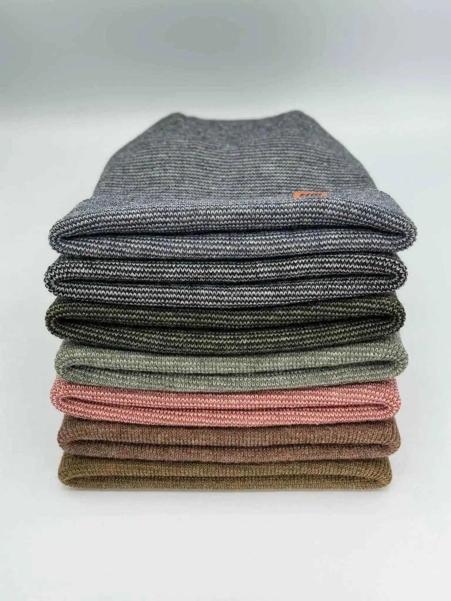 Cuffed knit beanie in burgundy-green fusion tones, folded stack