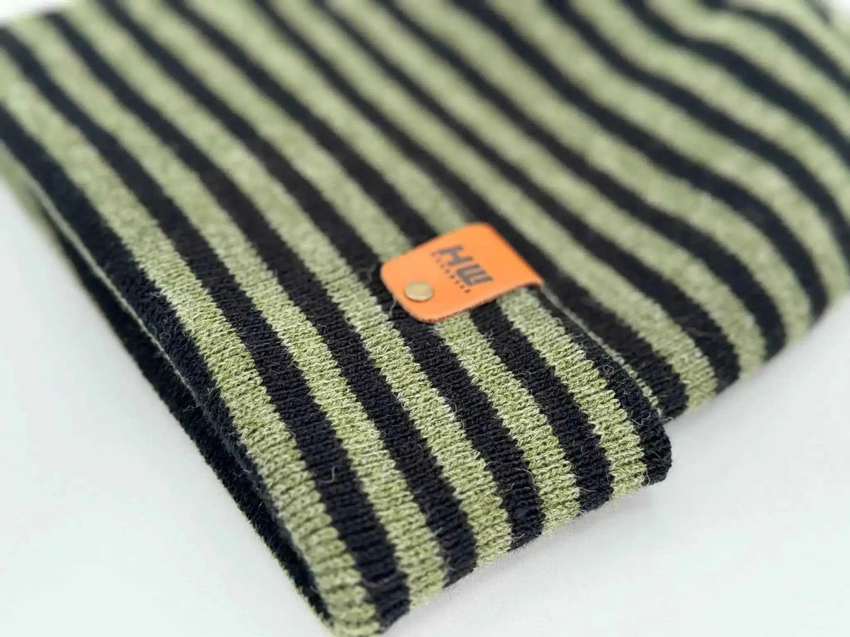 Cuffed striped knit beanie with orange sewn patch label near hem
