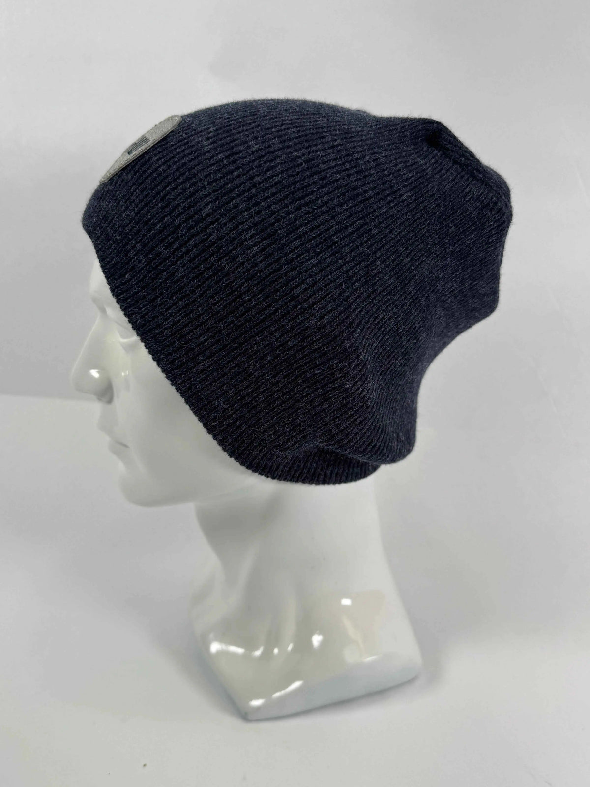 Navy knit beanie with un-cuffed ribbed edge and small HUI logo label on side.