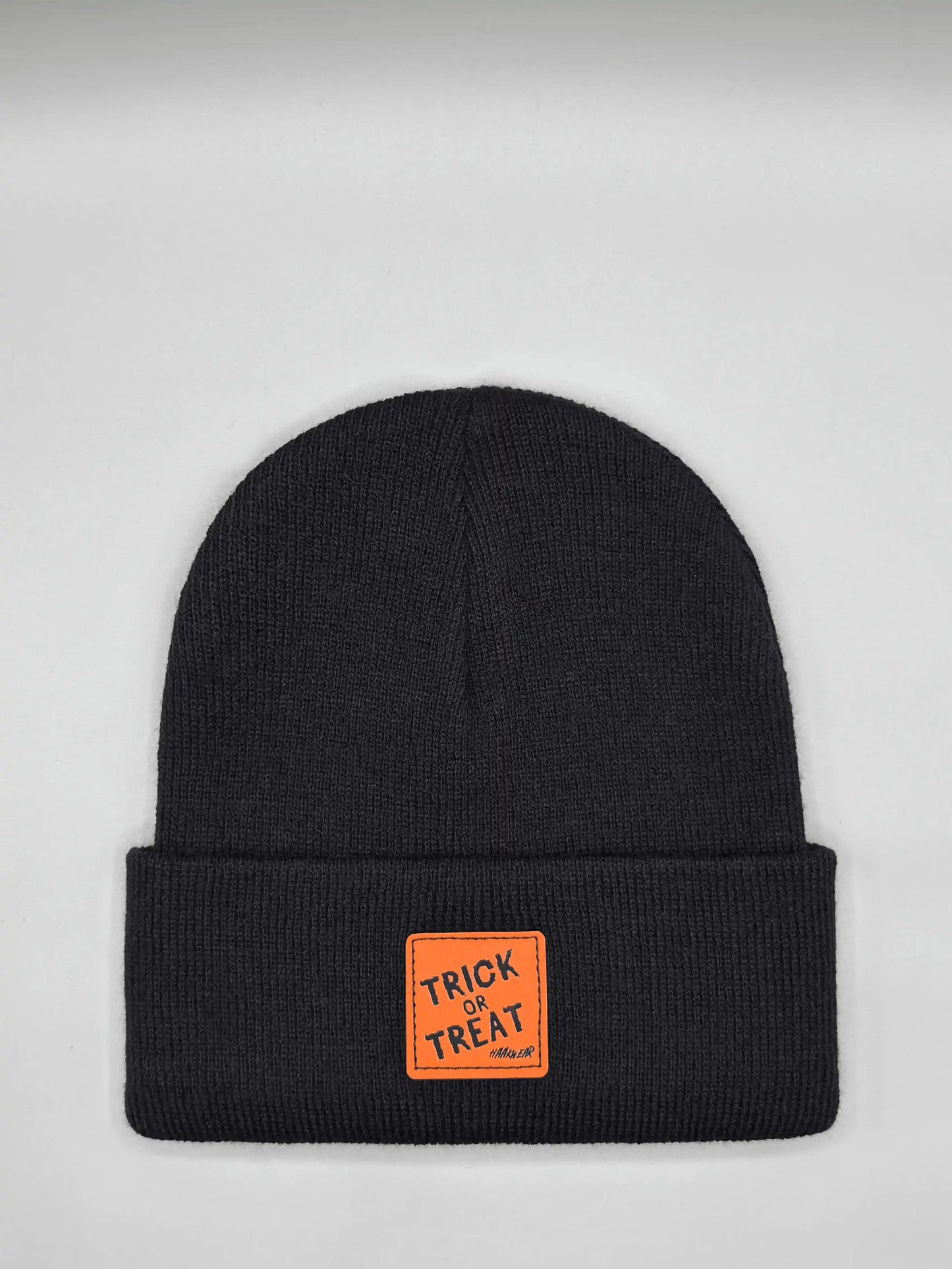 Dark Halloween beanie with orange “Trick or Treat” logo patch on cuff