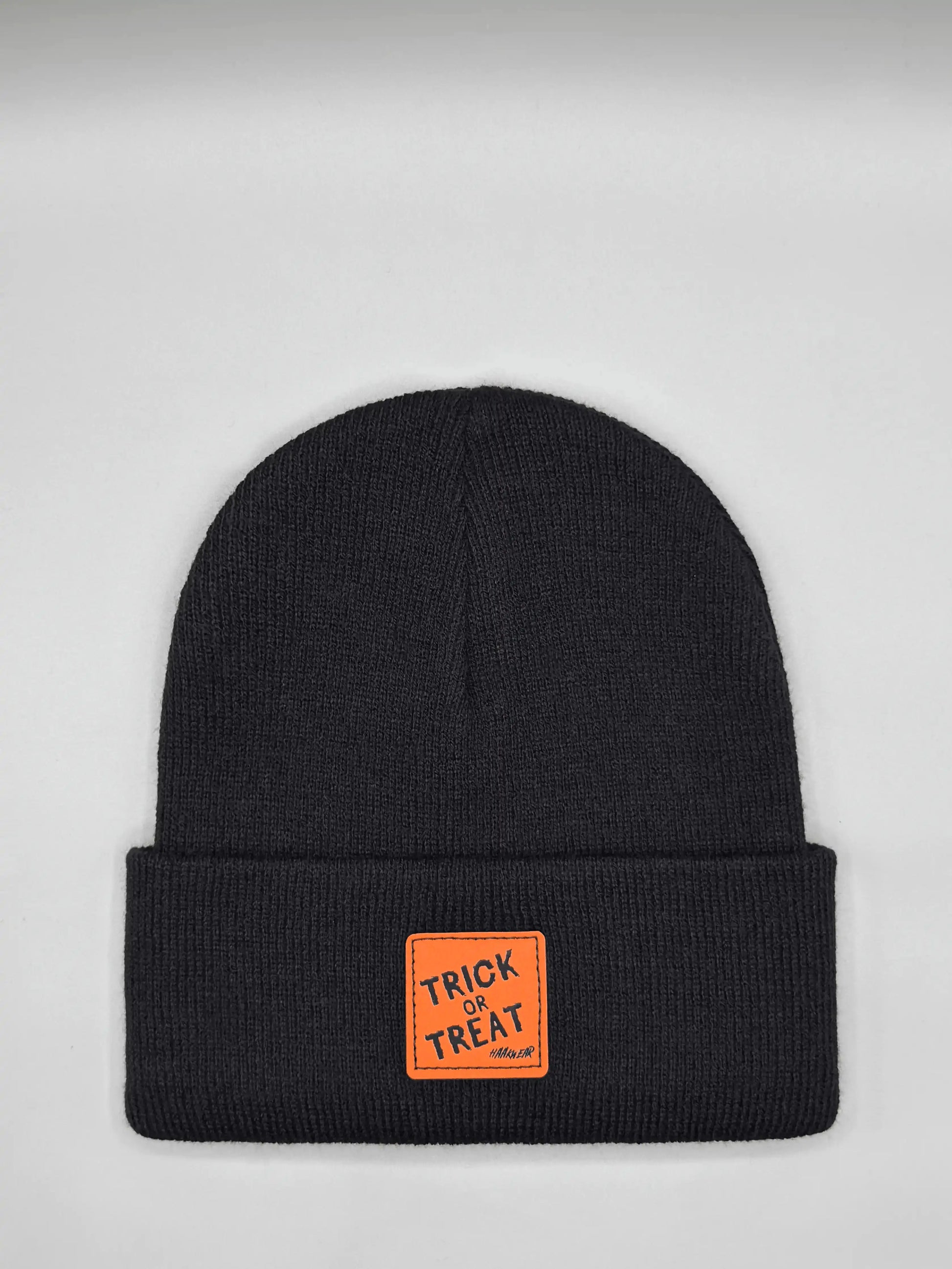 Dark Halloween beanie with orange “Trick or Treat” logo patch on cuff
