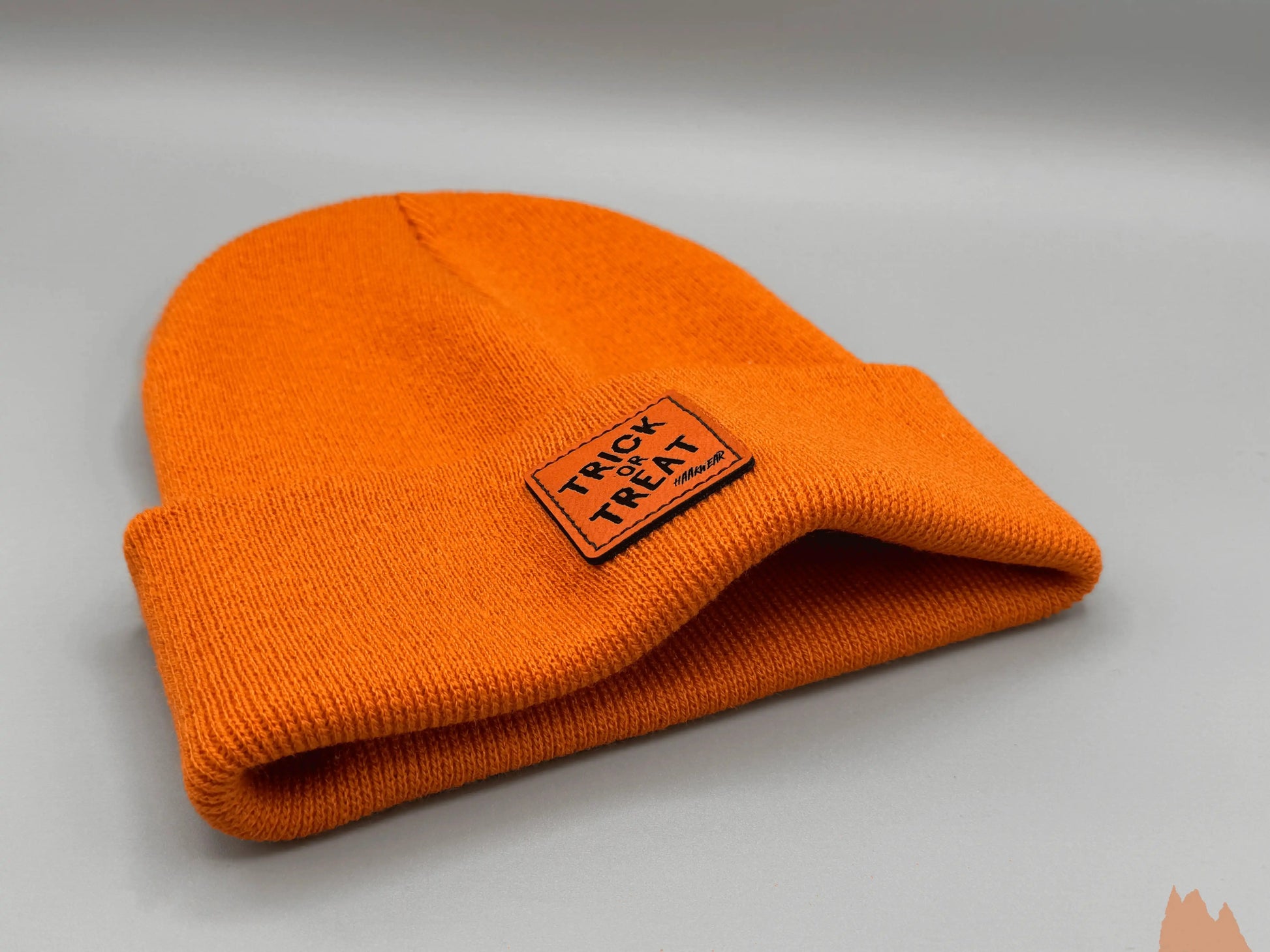 Orange knit beanie with small Trick or Treat patch on cuff
