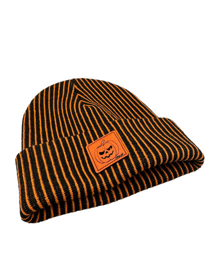 Striped knit beanie with orange pumpkin face patch and fold-over brim