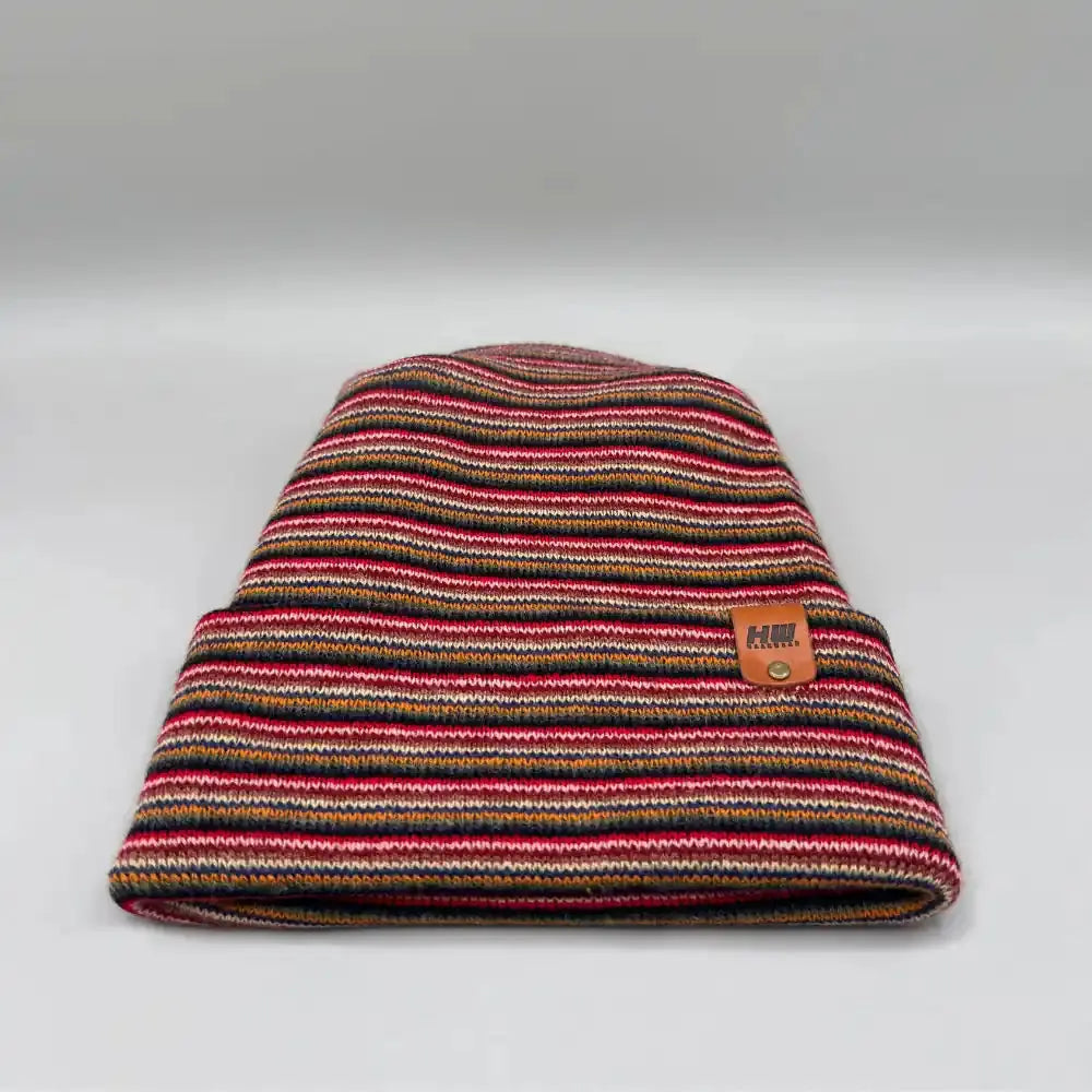 Multicolor striped knit beanie, cuffed top with H brand leather patch on side.