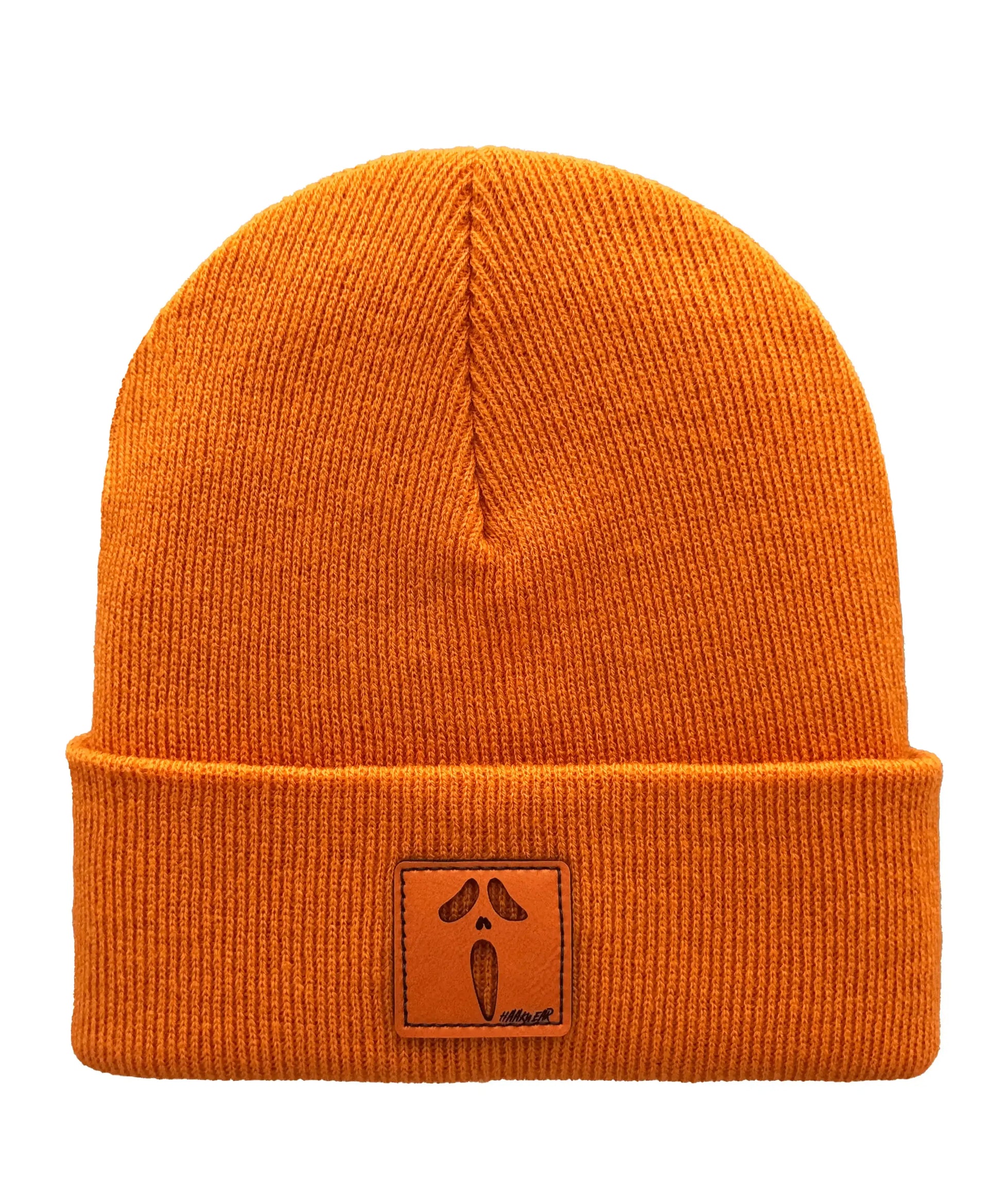 Orange knit beanie with ribbed cuff and square logo patch near front