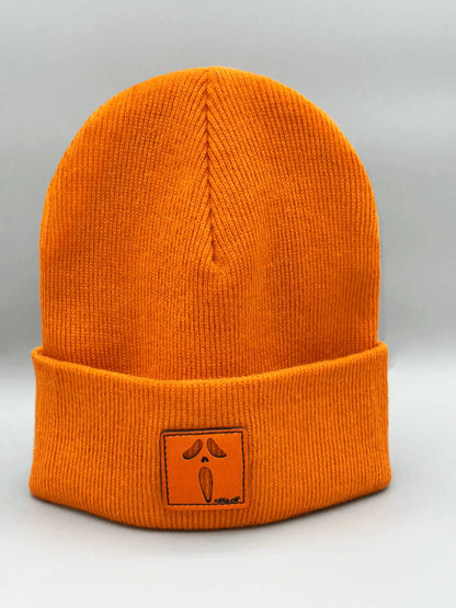 Orange knit beanie with ribbed cuff and square logo patch centered