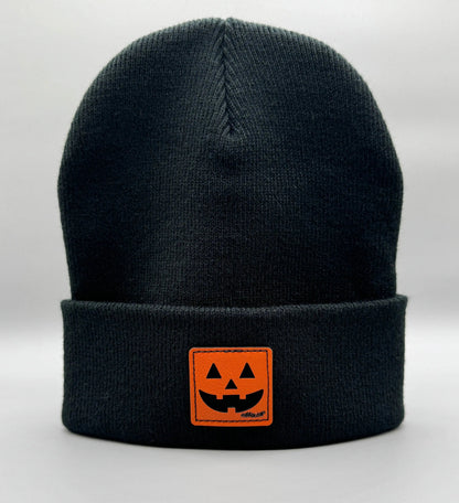 Black beanie with fold-over cuff and orange jack-o-lantern logo patch