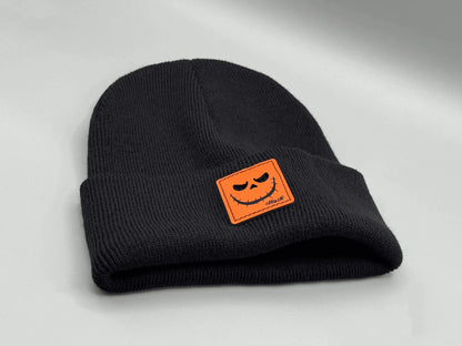 Black knit beanie with orange jack-o-lantern patch on front