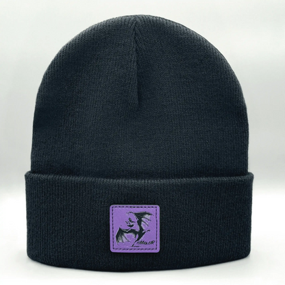 Dark navy knit beanie with purple square patch featuring a witch silhouette