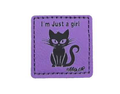 Purple stitched cat patch with "I'm Just a girl" text and cat graphic.