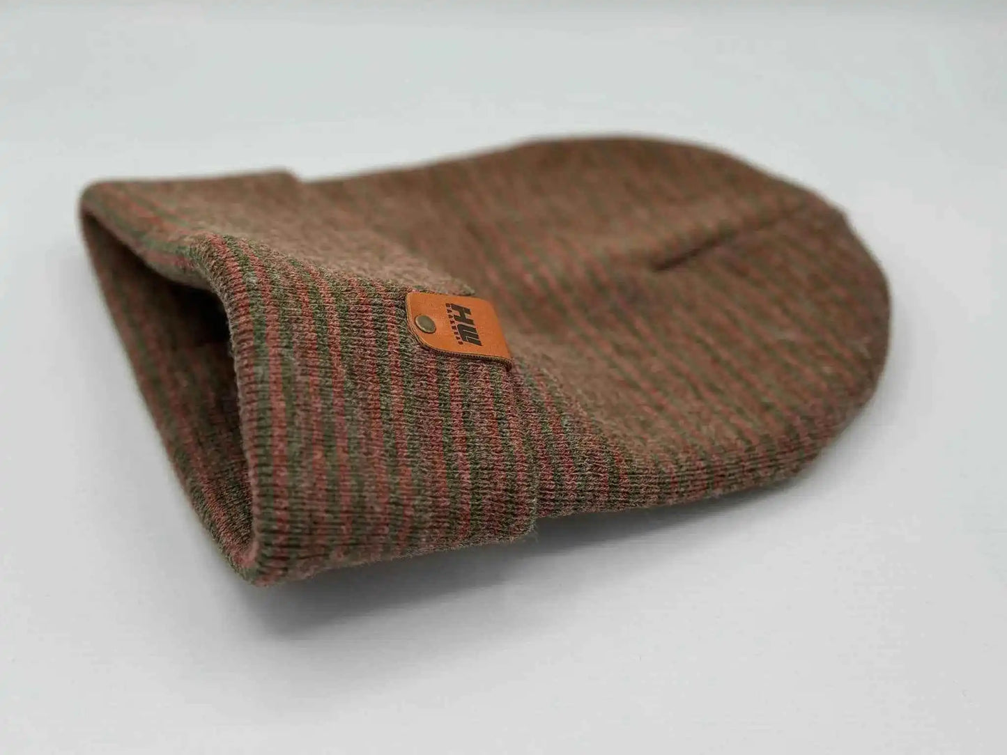 Burgundy/green contrast cuff beanie folded, showing ribbed knit and orange logo tag