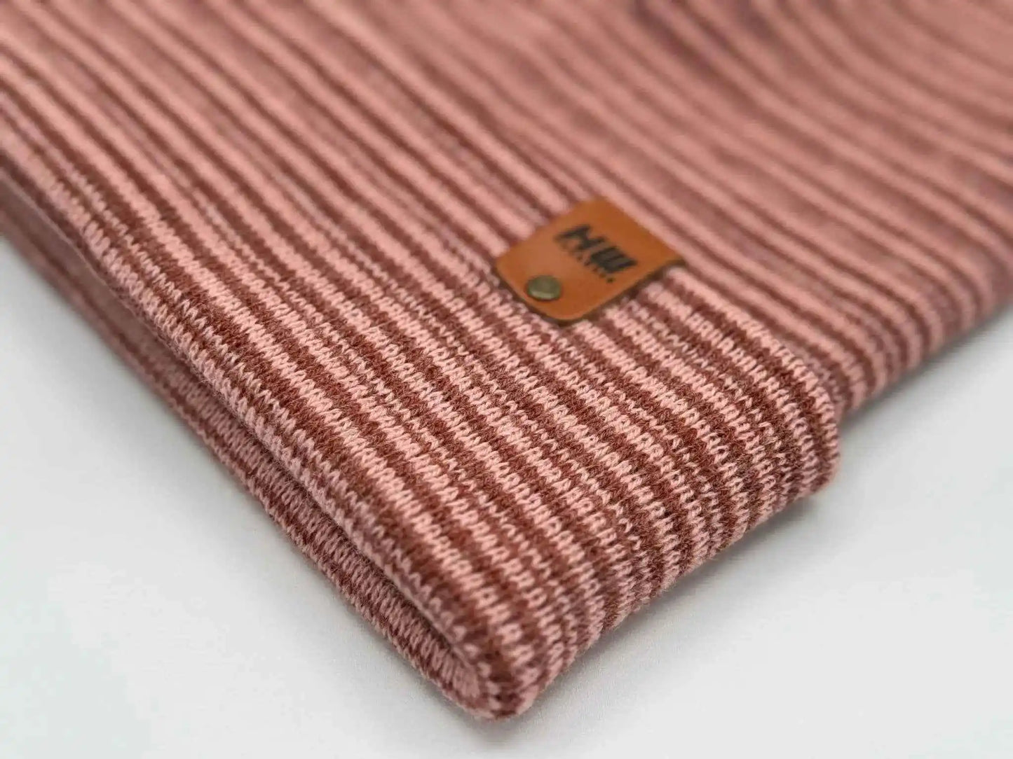 Striped knit cuff on burgundy beanie with front logo patch close-up