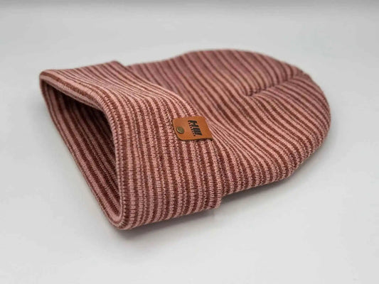 Folded burgundy beanie with pink knit stripes and small square logo patch