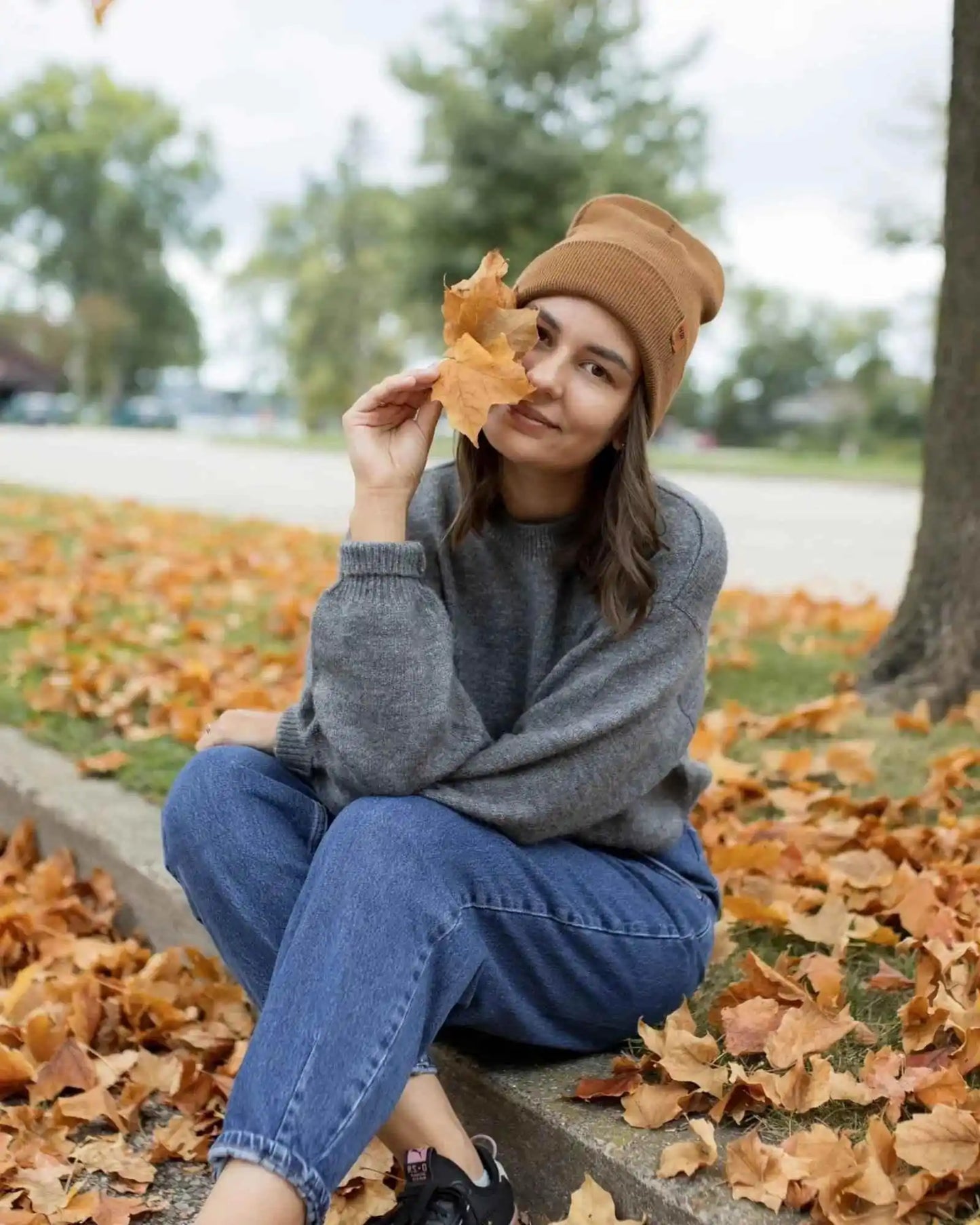 Camel brown beanie with folded cuff, worn by woman outdoors