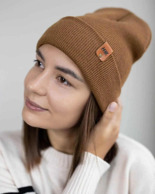 Camel brown beanie on model, ribbed knit cuff and logo patch