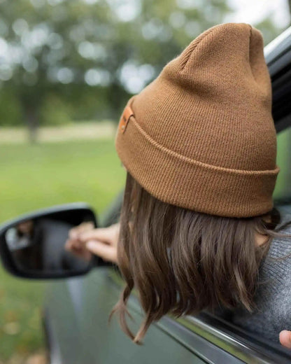 Camel brown knit beanie, folded cuff visible, small side logo patch