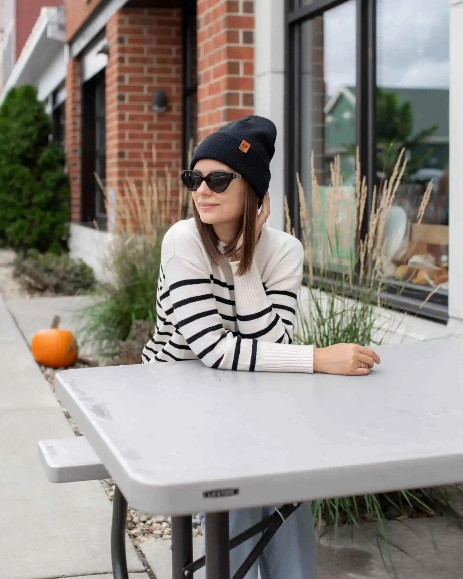 Charcoal black cuffed beanie with fold-over brim and small leather logo tag on side.
