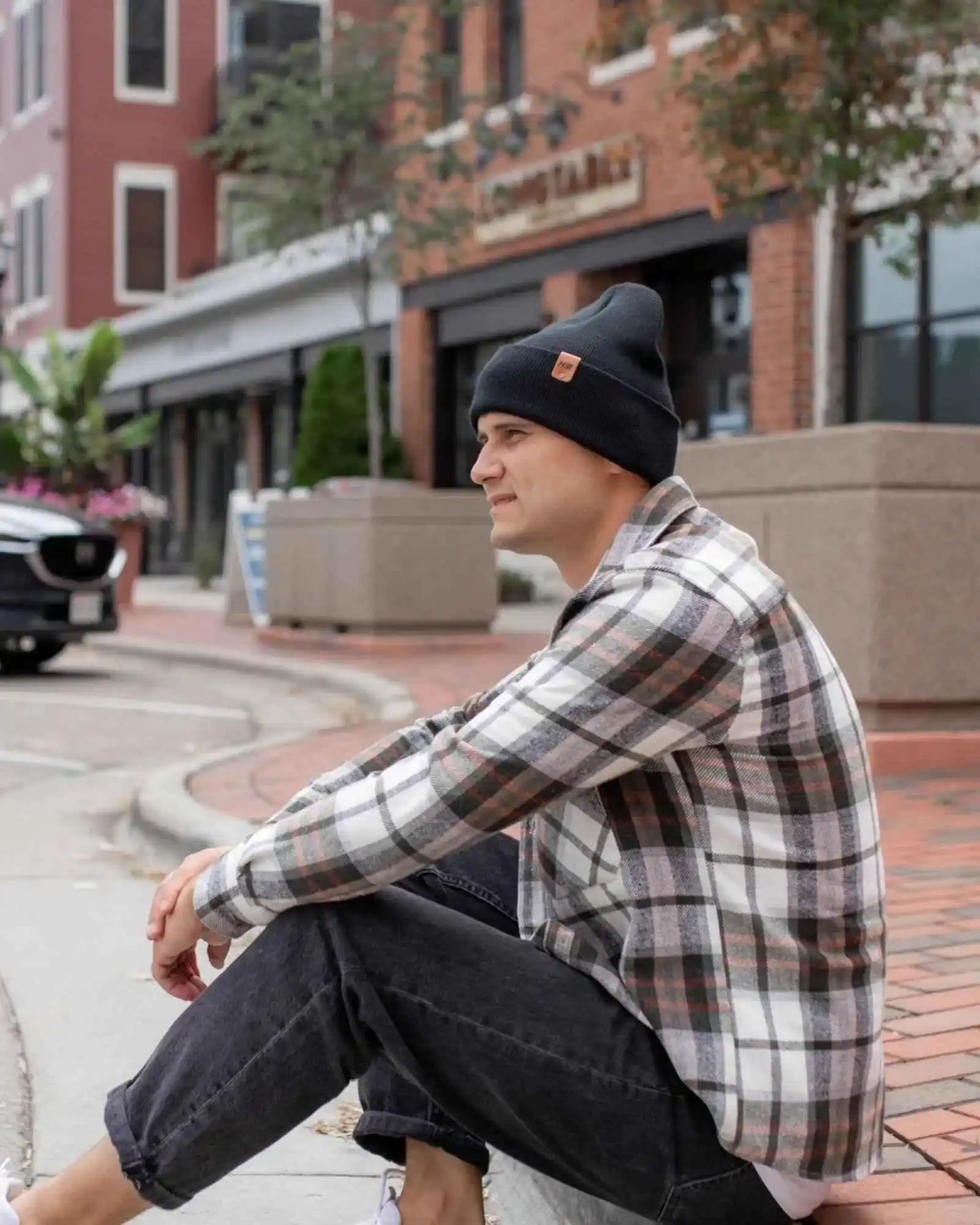 Charcoal black cuffed knit beanie with small leather patch.