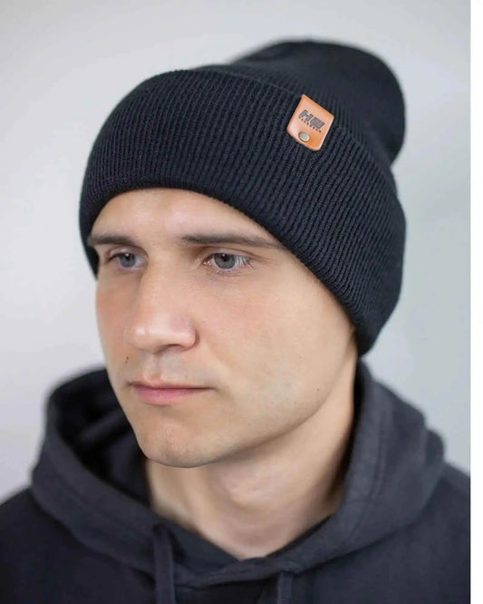 Charcoal black cuffed beanie with side logo patch and fold-over brim.