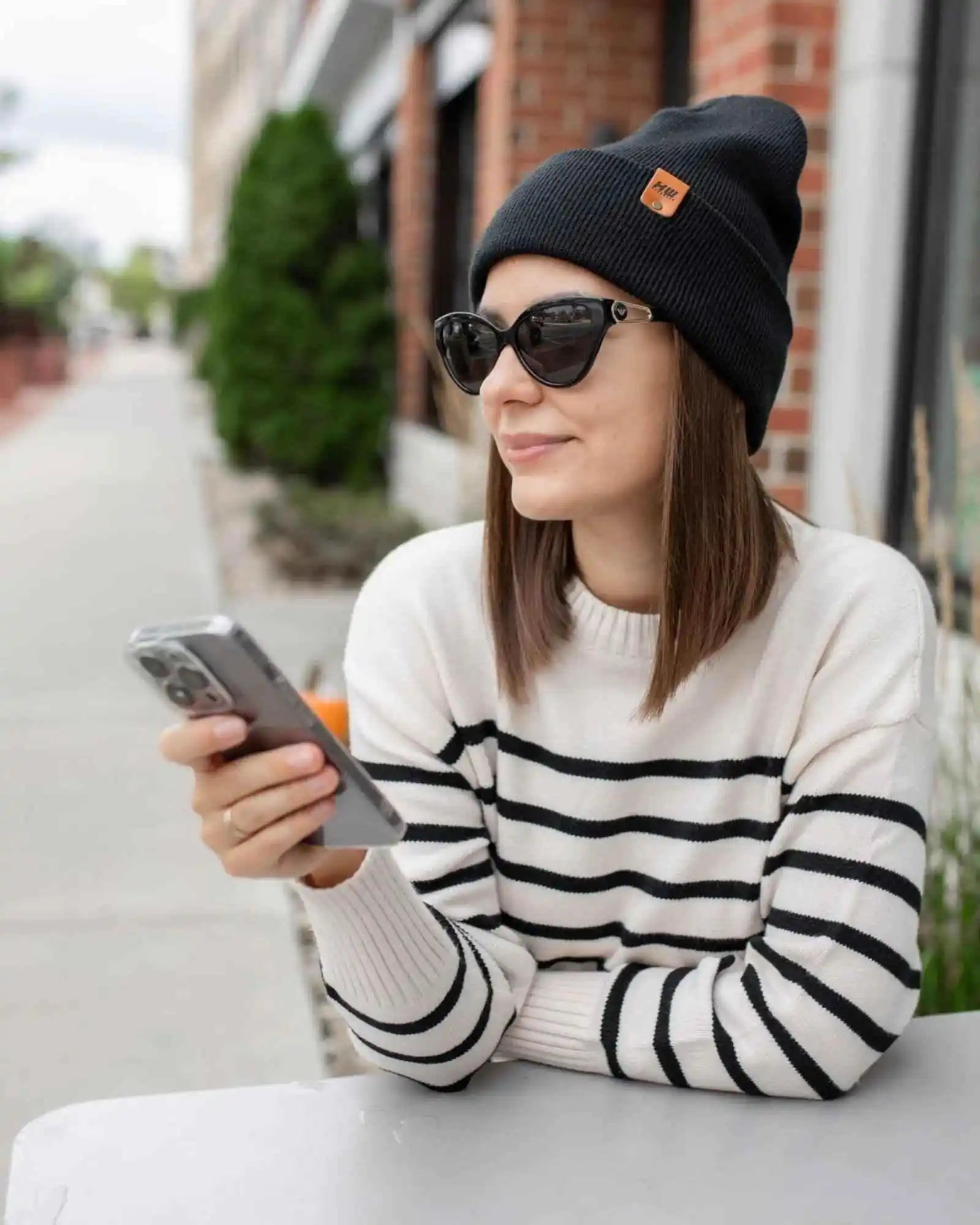 Charcoal black cuffed knit beanie with fold-over brim and rectangular logo patch.