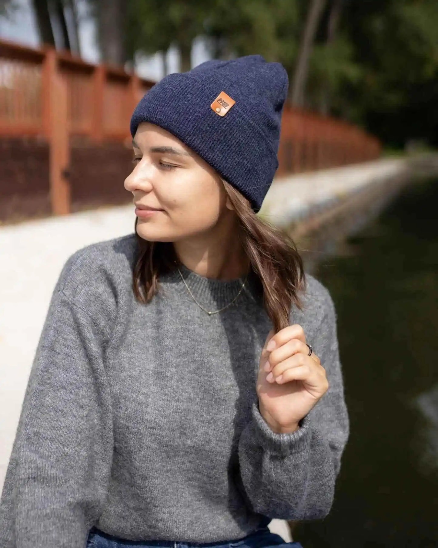 Denim blue rib-knit beanie with folded cuff and tan logo patch