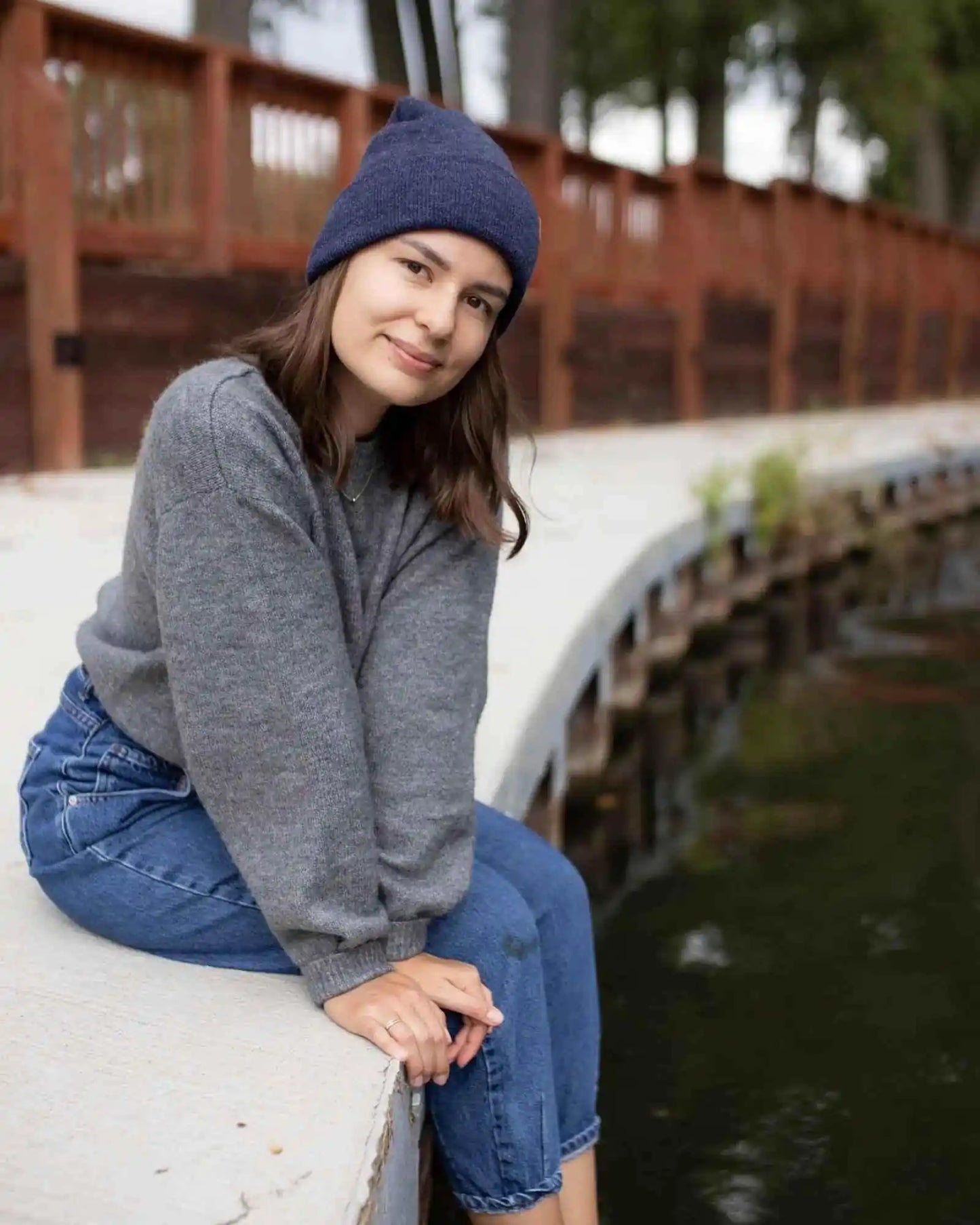 Denim blue knit beanie with folded cuff and tan logo patch