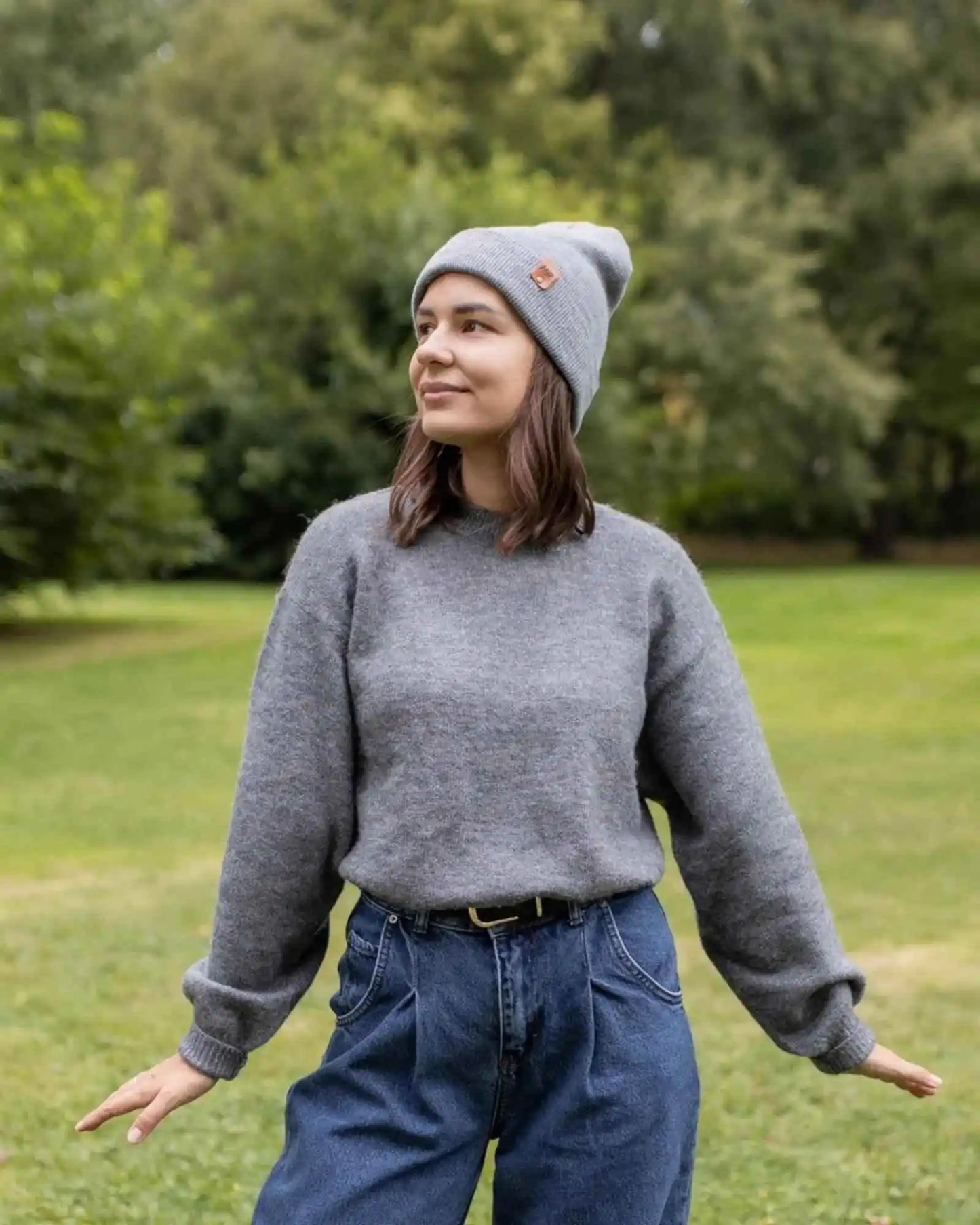Koala gray cuffed beanie hat on model, knit ribbed cuff and small leather logo patch.
