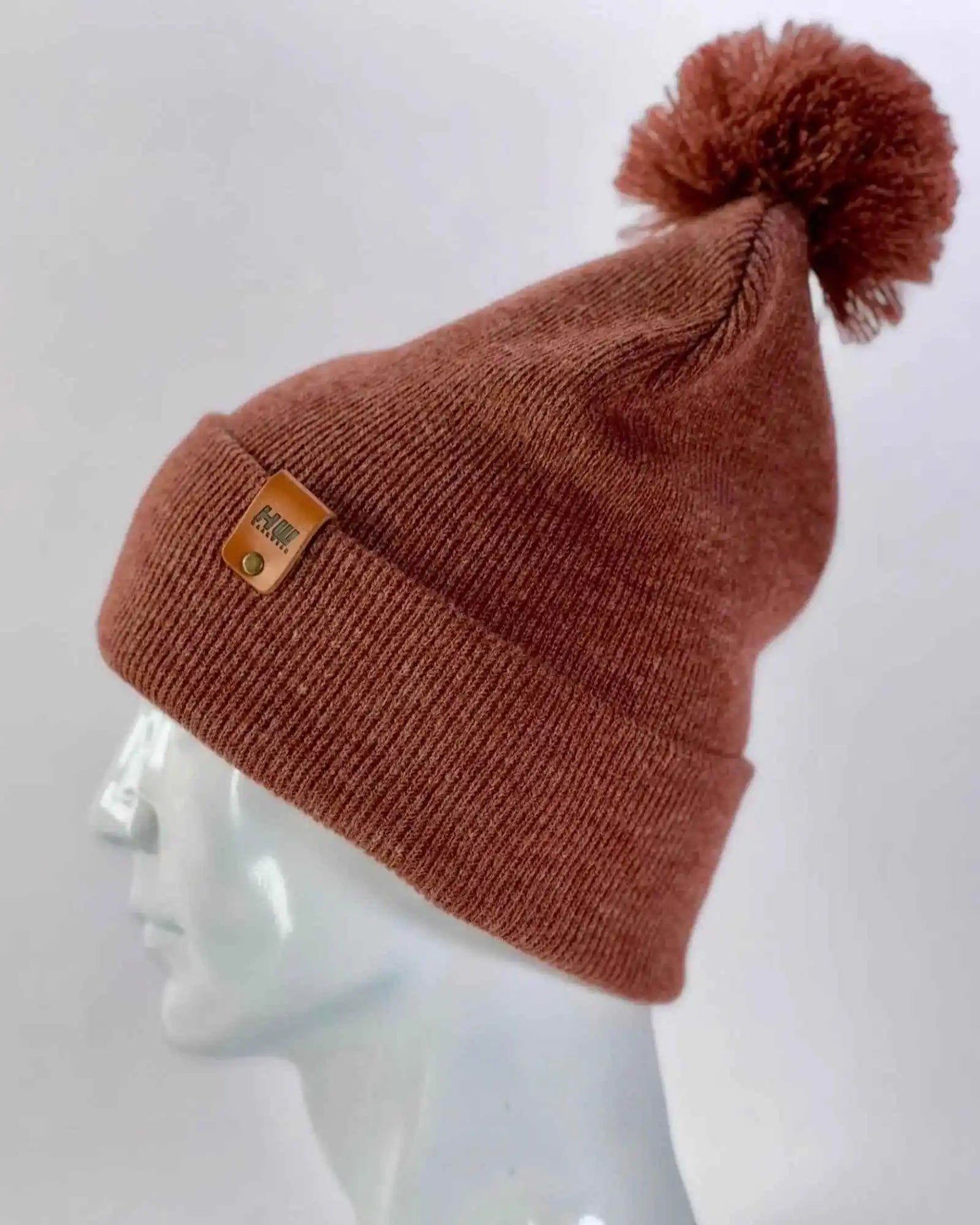 Rusty burgundy knit pom pom beanie with logo patch on cuff