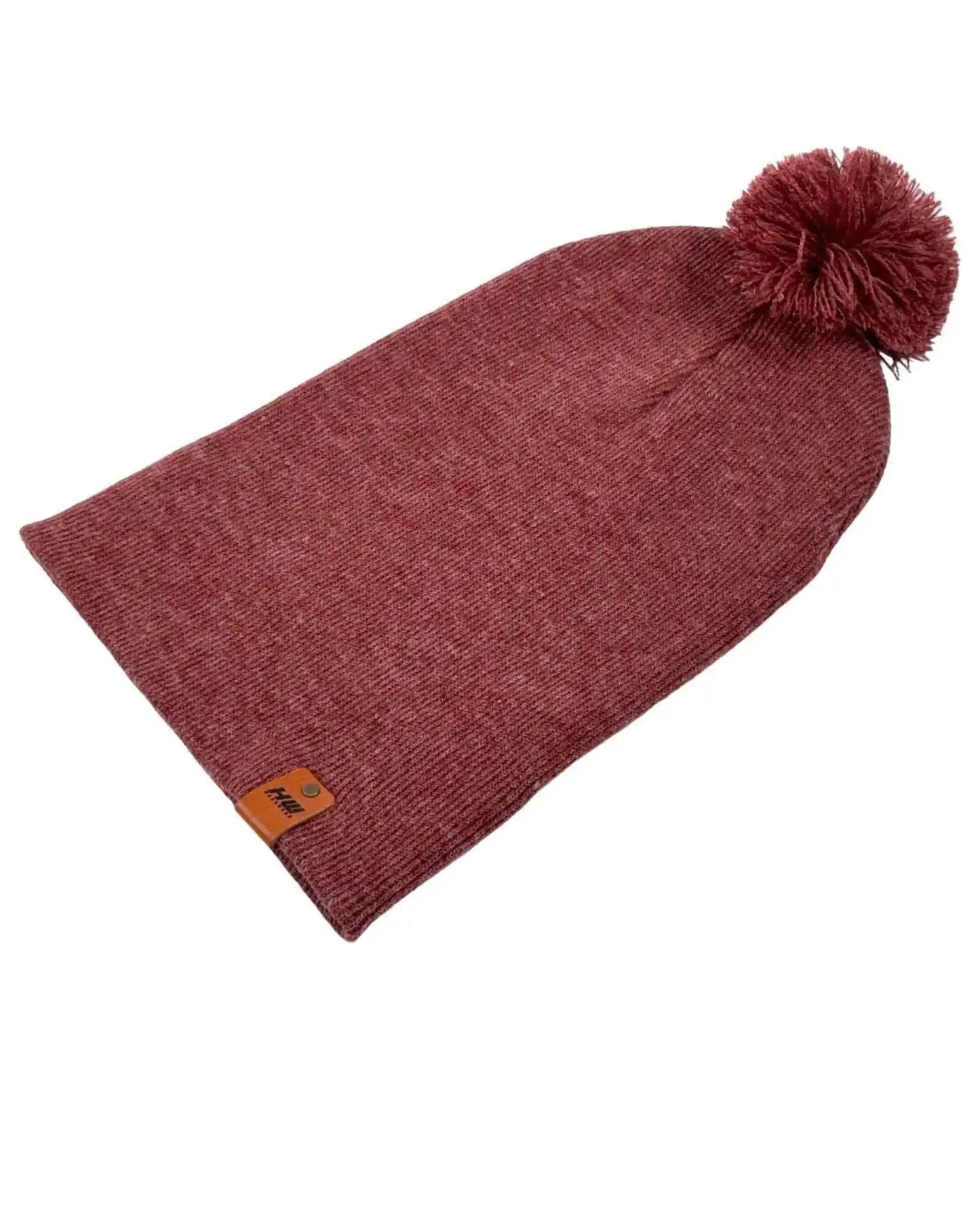 Rusty burgundy knit beanie with pom pom and small logo patch on front