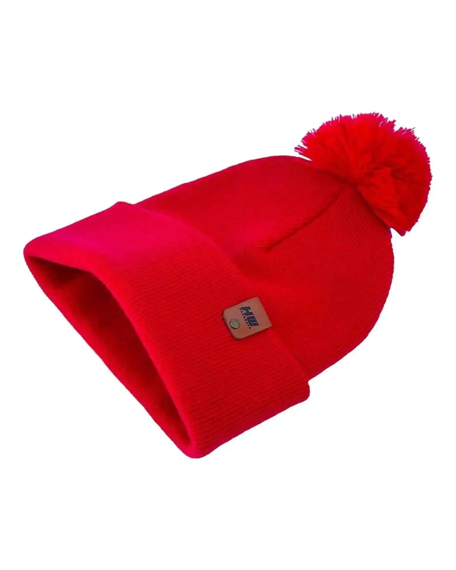 Red cuffed knit beanie with pom pom and square fabric logo patch