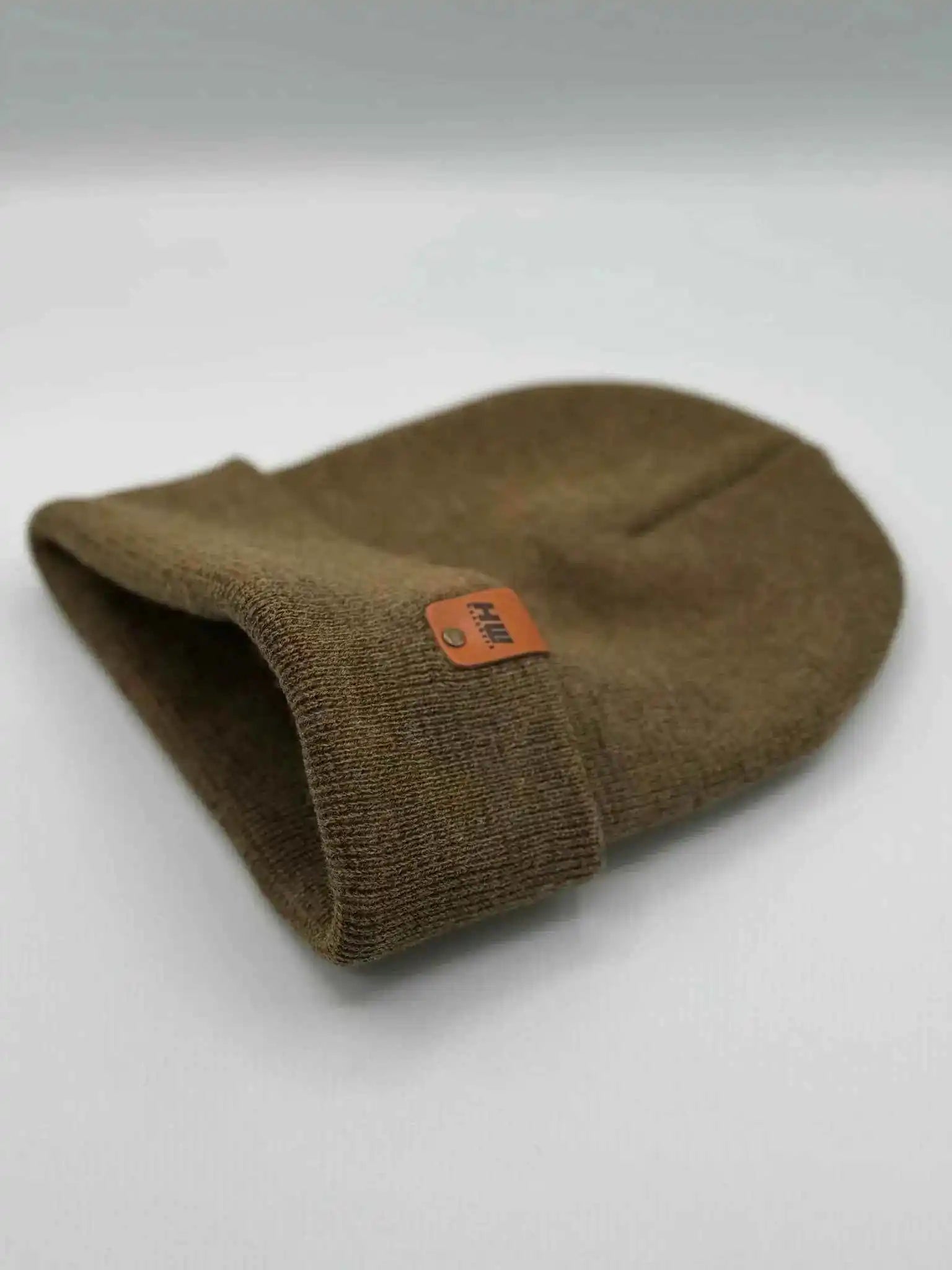 Folded cuff beanie in brown-green knit with orange logo patch