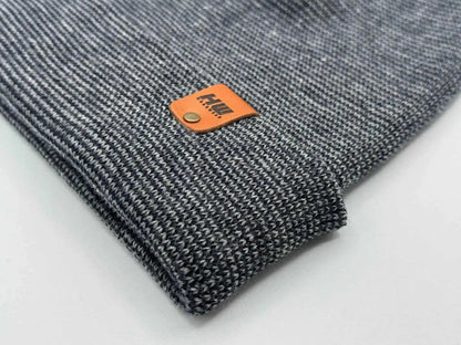 Close-up of gray knit cuffed beanie with orange logo patch