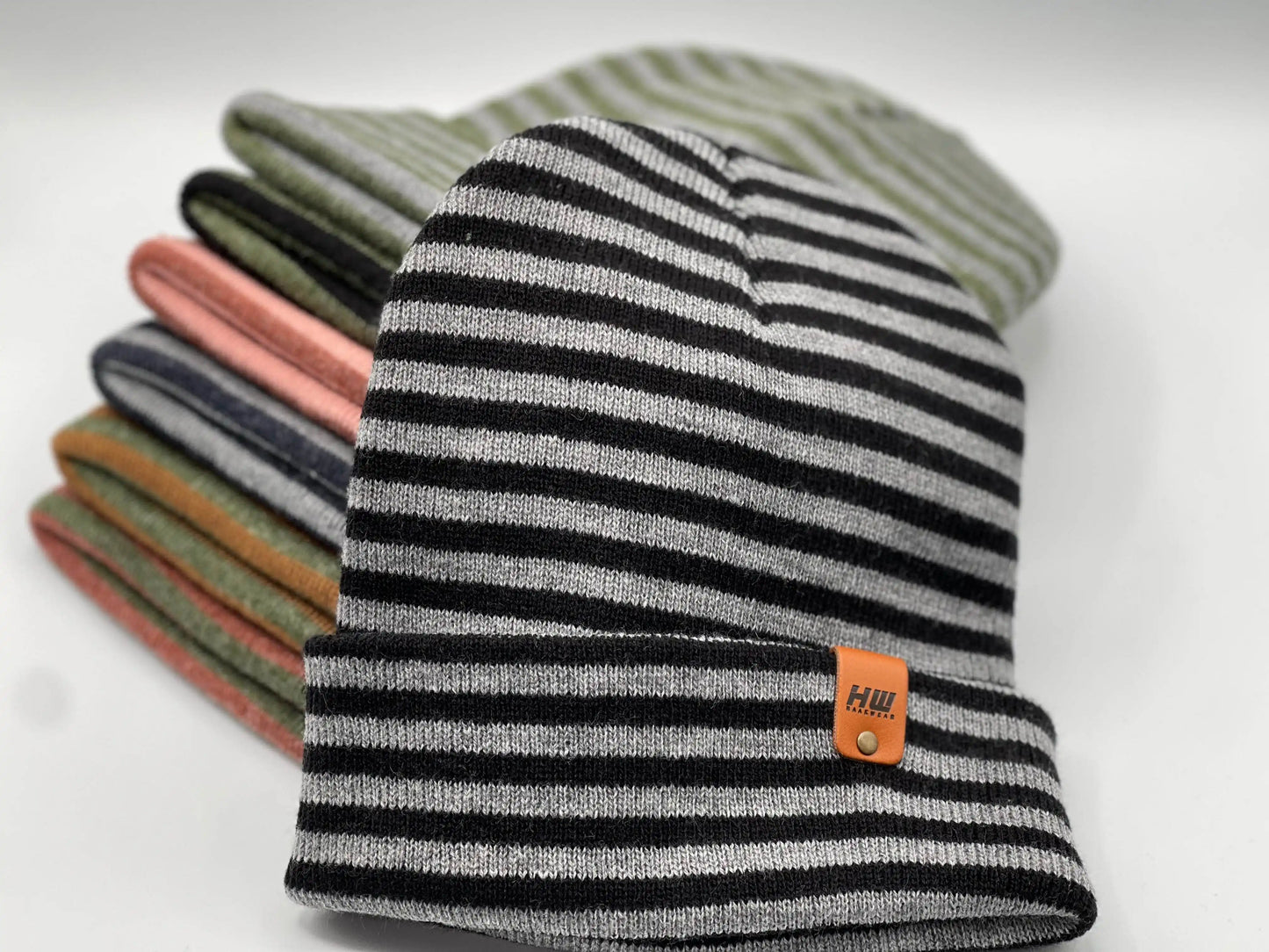 Cuffed beanie in black, gray, and light stripes with logo patch