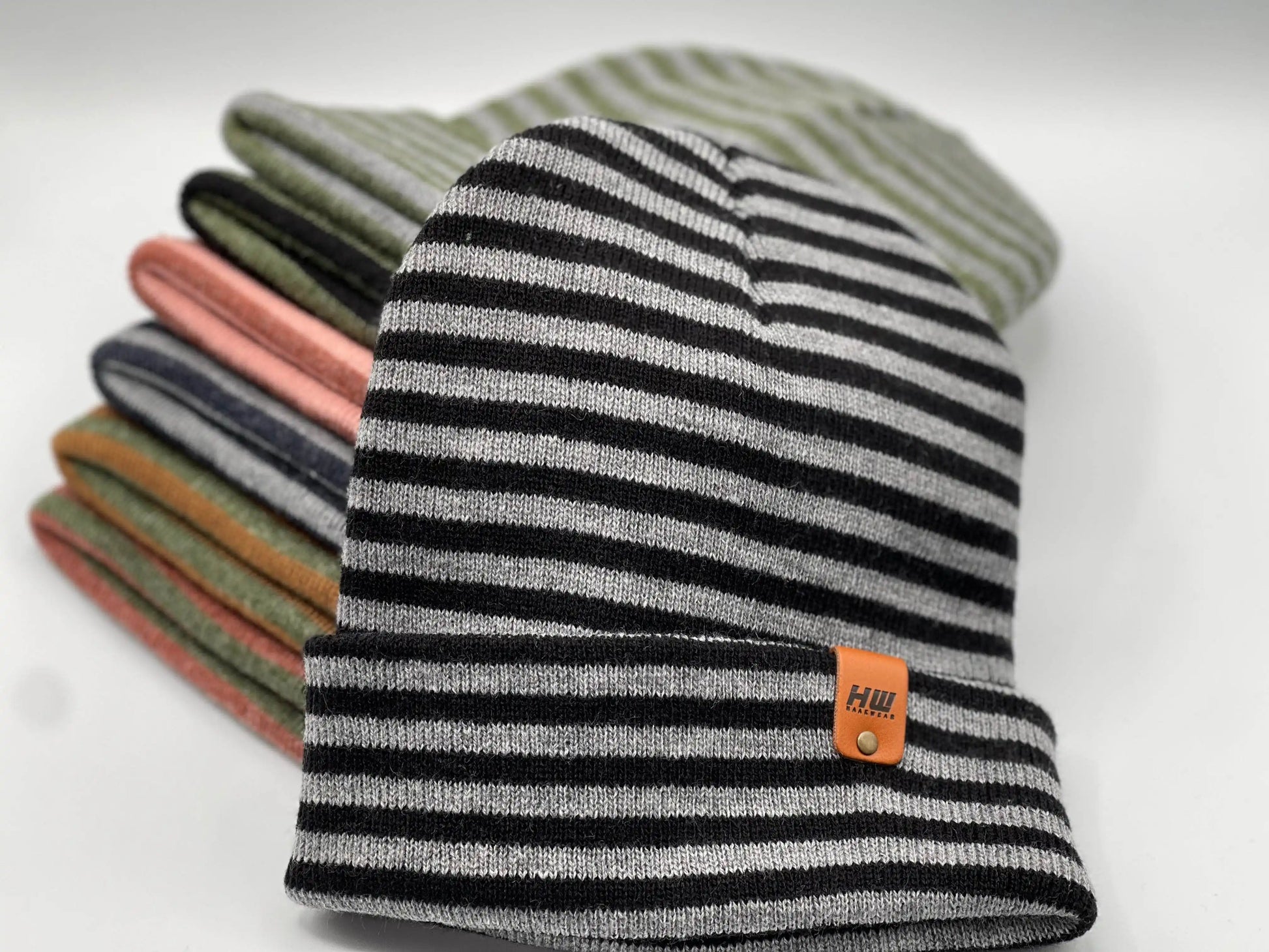 Cuffed beanie in black, gray, and light stripes with logo patch