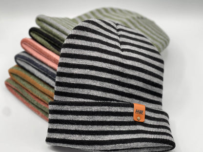 Cuffed beanie in black, gray, and light stripes with logo patch