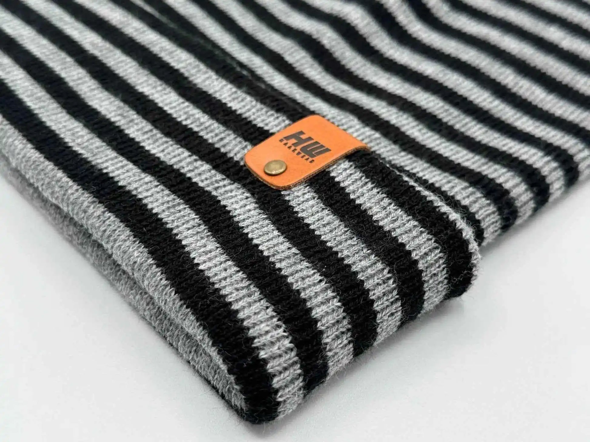 Striped knit cuff beanie with orange logo leather patch