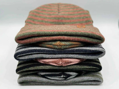 Stack of cuffed beanies showing burgundy, green, and dark stripe bands