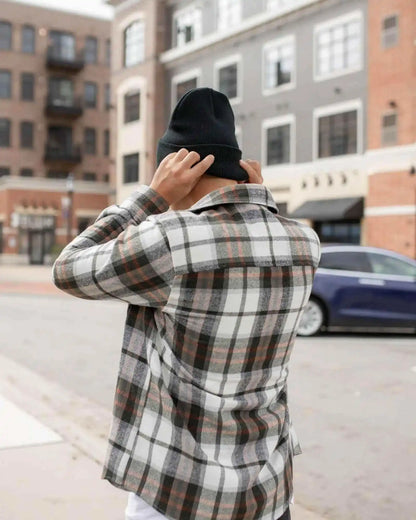 Charcoal black cuffed beanie on head, worn with plaid jacket