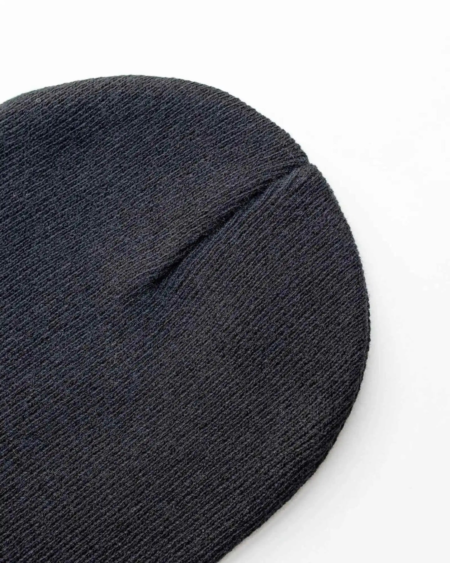 Charcoal black knit beanie close-up with folded cuff seam