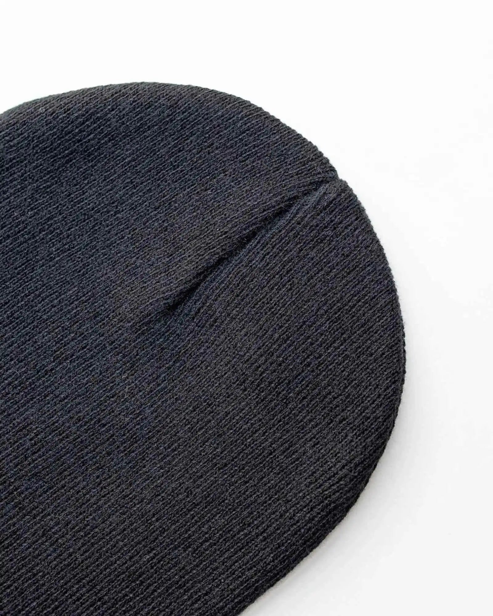 Charcoal black knit beanie close-up with folded cuff seam