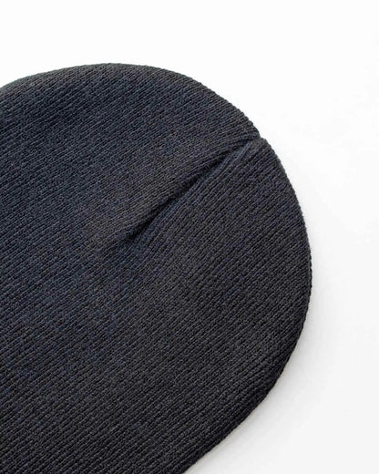 Charcoal black knit beanie close-up with folded cuff seam