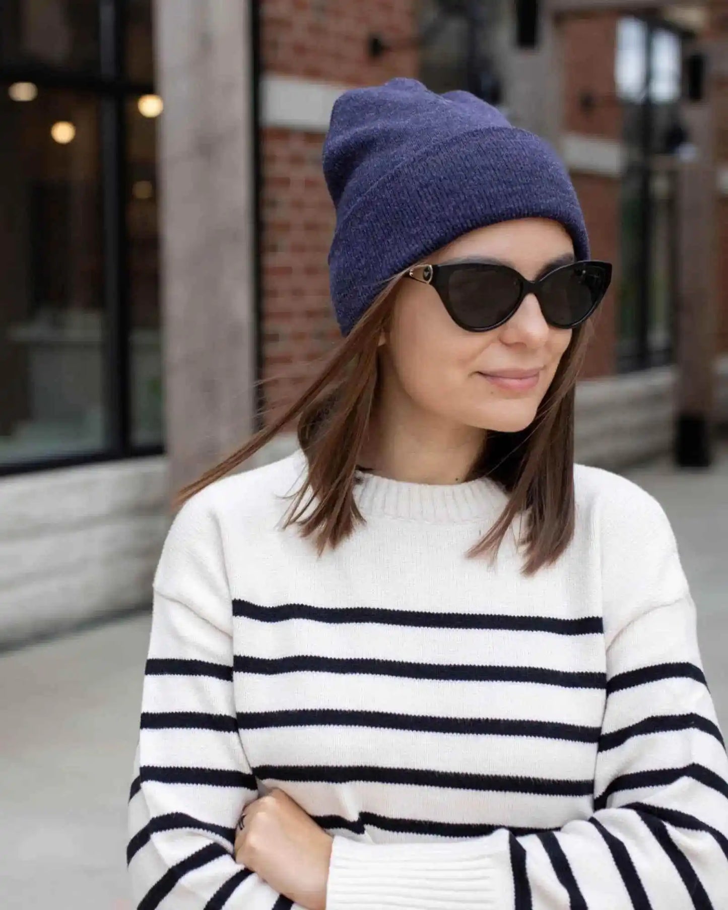 Denim blue cuffed knit beanie worn with sunglasses