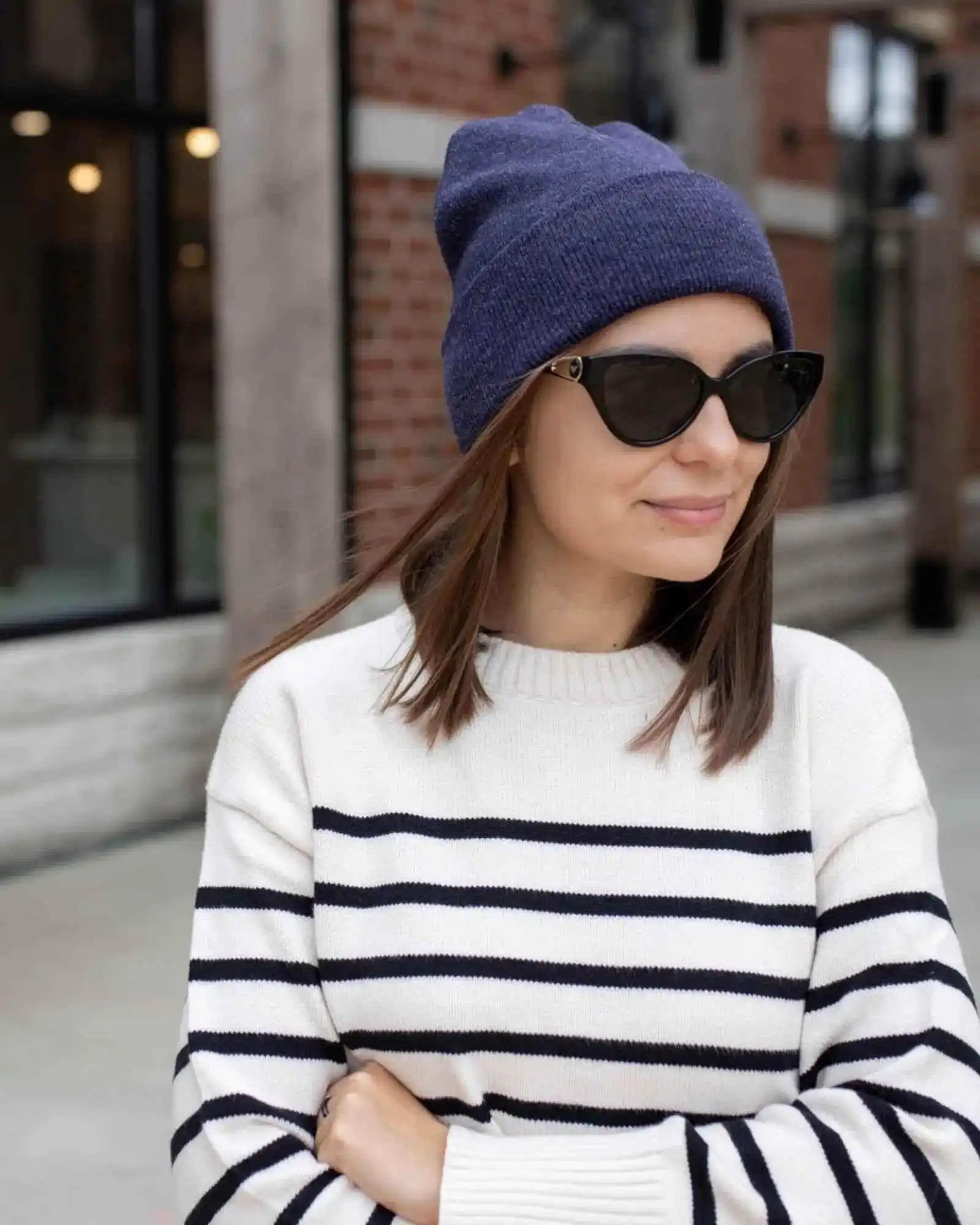 Denim blue cuffed knit beanie worn with sunglasses