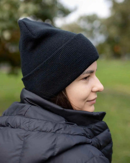 Midnight black knit beanie on head, folded cuff