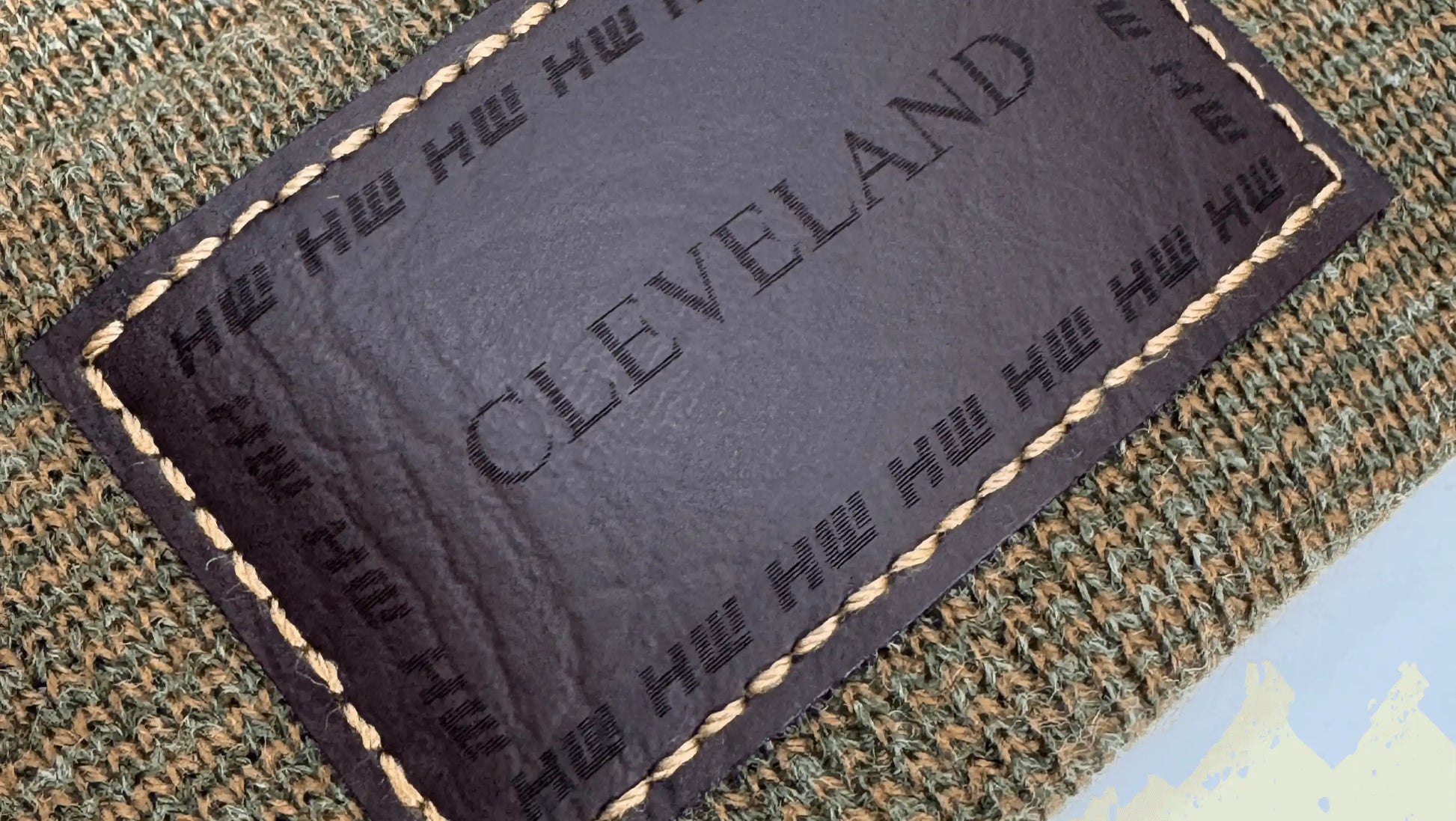Brown and green knit beanie showing rectangular Cleveland label patch detail