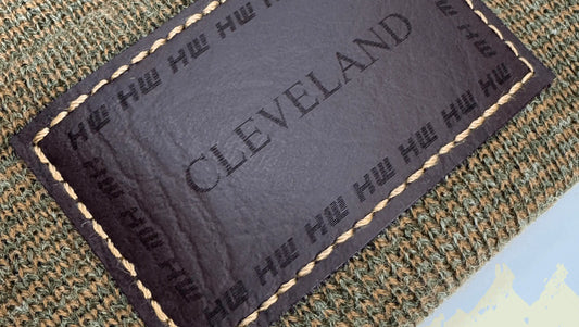 Brown and green knit beanie showing rectangular Cleveland label patch detail