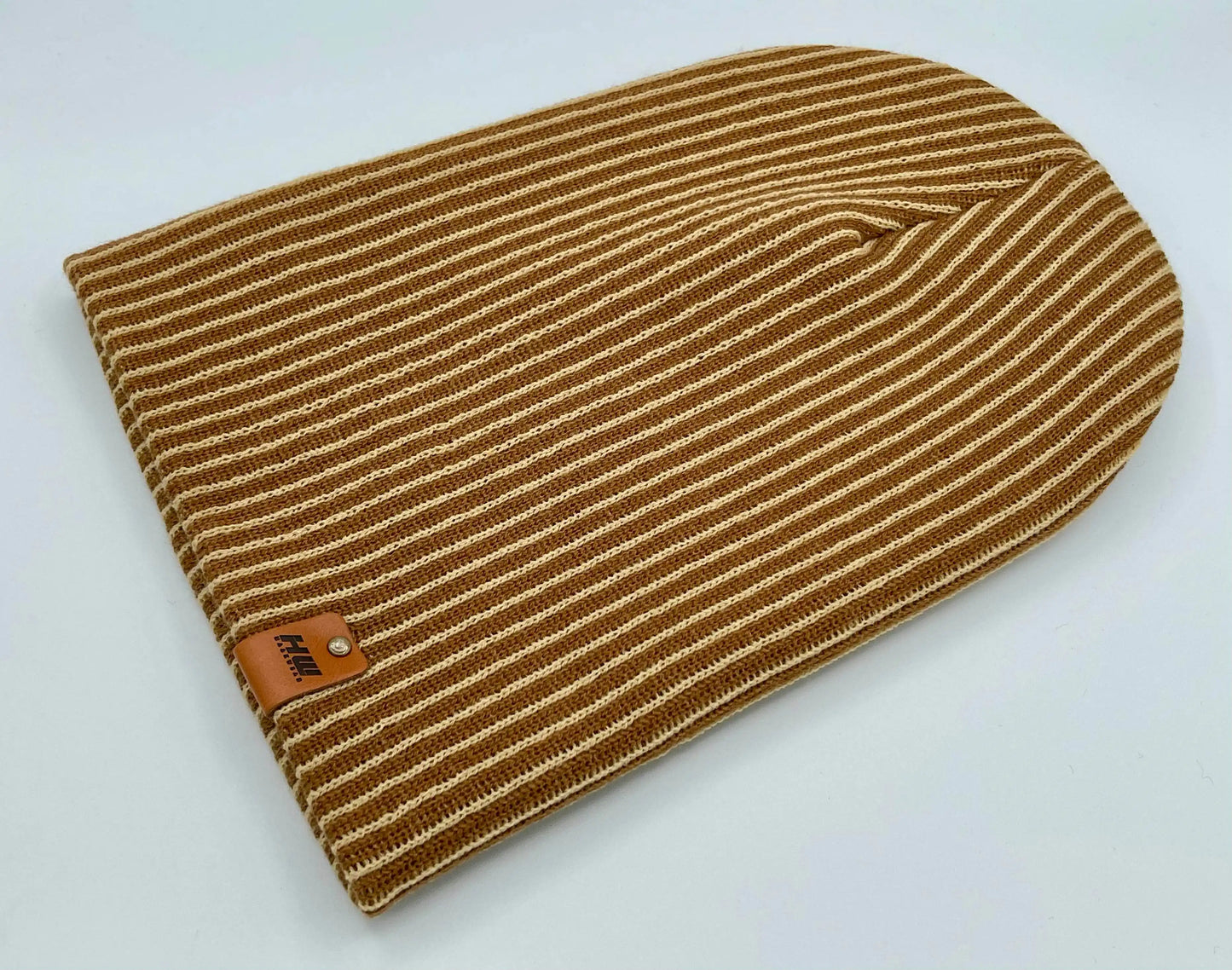 Folded beige and brown striped rib beanie with leather logo patch on cuff, knit texture
